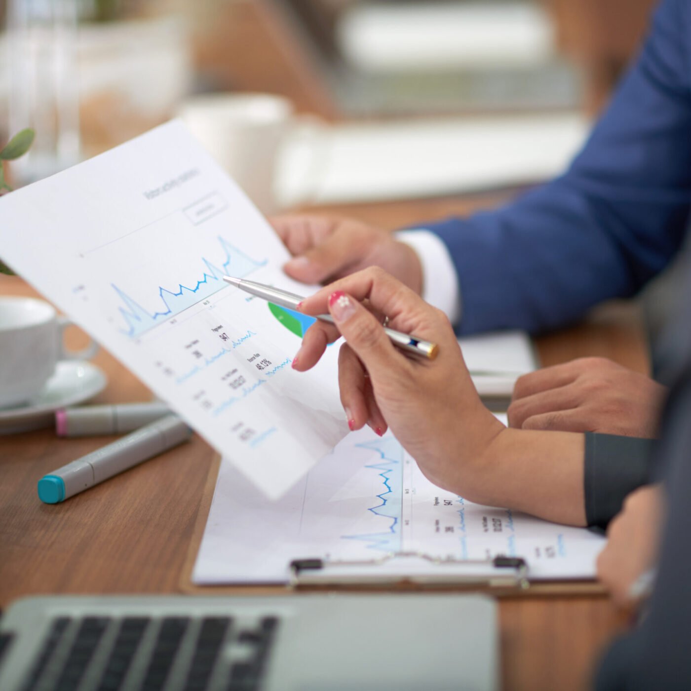 hands-man-woman-business-attire-sitting-desk-office-discussing-graph